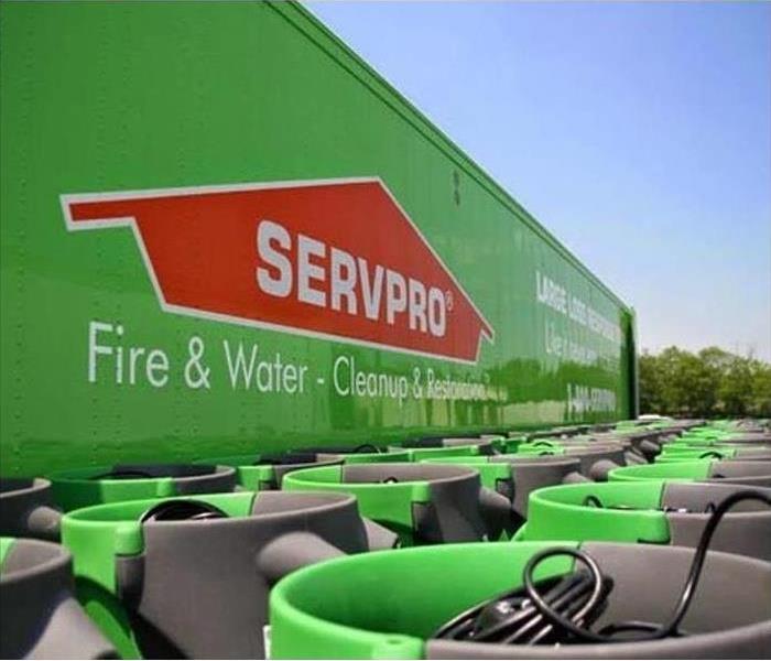Large SERVPRO trailer lined with air movers outside.