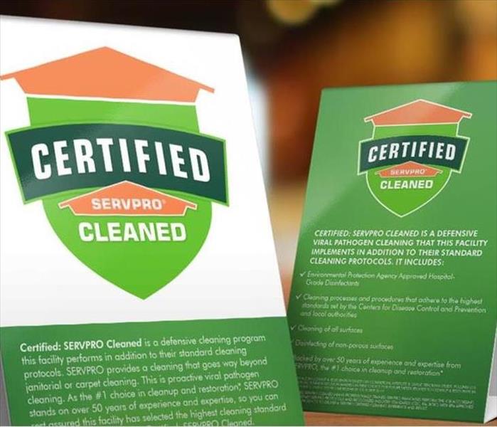 Table tent signs describing the Certified: SERVPRO Cleaned program on top of a wooden table.